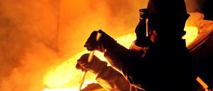 Ein Arbeiter entfernt in der Edelstahl-Gießerei Otto Junker in Simmerath (Kreis Aachen) Schlacke.