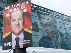 Wahlkampf zur Bundestagswahl 2025 in Berlin: Plakat des damals noch amtierenden Kanzlers Olaf Scholz (SPD), im Hintergrund sein Herausforderer und heutiger Kanzler Friedrich Merz (CDU).