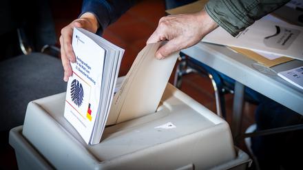 Ein Mann wirft am Sonntag, 23.02.2025, seinen Wahlzettel zur Bundestagswahl 2025 in die Wahlurne des Wahlbezirks 272.