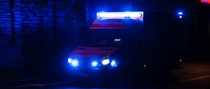 Ein Krankenwagen fährt nachts mit Blaulicht durch eine Straße. (Symbolbild)
