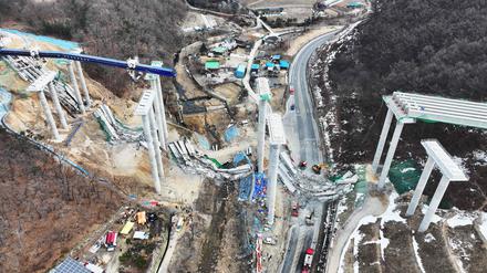 Rettungskräfte suchen nach dem Einsturz einer Brücke auf einer Schnellstraßenbaustelle in Anseong am 25. Februar 2025 nach vermissten Arbeitern.