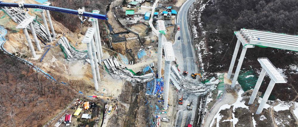 Rettungskräfte suchen nach dem Einsturz einer Brücke auf einer Schnellstraßenbaustelle in Anseong am 25. Februar 2025 nach vermissten Arbeitern.