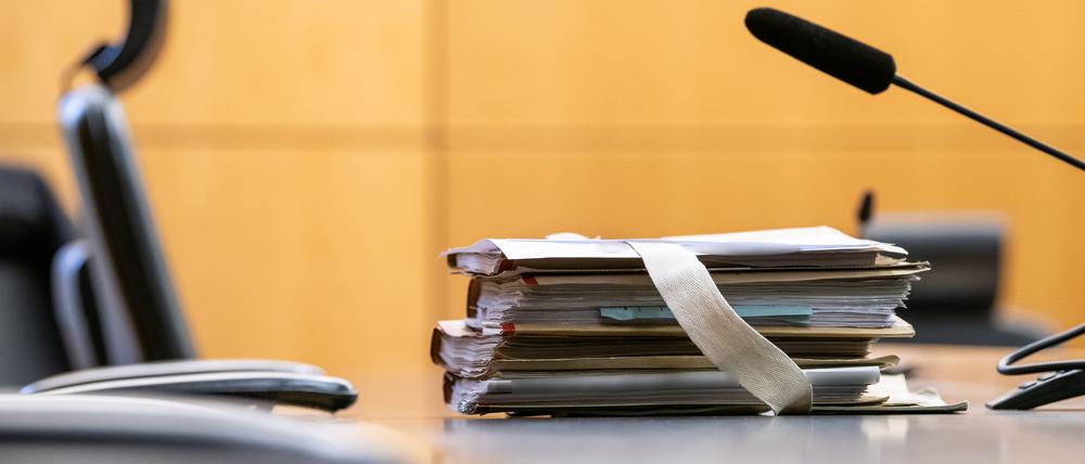 Akten liegen in einem Saal des Landgerichts in Darmstadt vor Beginn eines Prozesses am Platz des Richters.