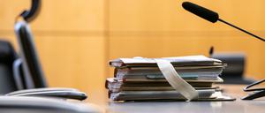 Akten liegen in einem Saal des Landgerichts in Darmstadt vor Beginn eines Prozesses am Platz des Richters.