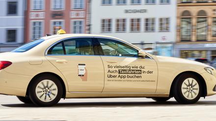 Ein Taxi mit Werbung des Fahrtenvermittlers Uber.