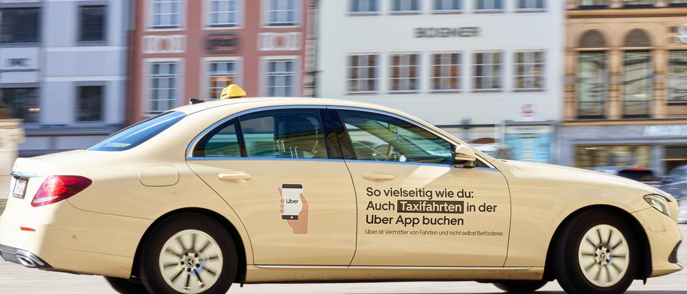 Ein Taxi mit Werbung des Fahrtenvermittlers Uber.