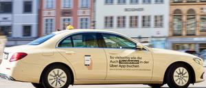 Ein Taxi mit Werbung des Fahrtenvermittlers Uber.