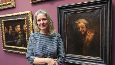 Anja Sevcik steht zwischen einem Selbstbildnis von Peter Paul Rubens unter Freunden (links) und einem Selbstbildnis von Rembrandt (rechts). 