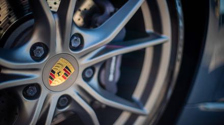 Das Porsche-Logo ist auf der Felge eines Autos.