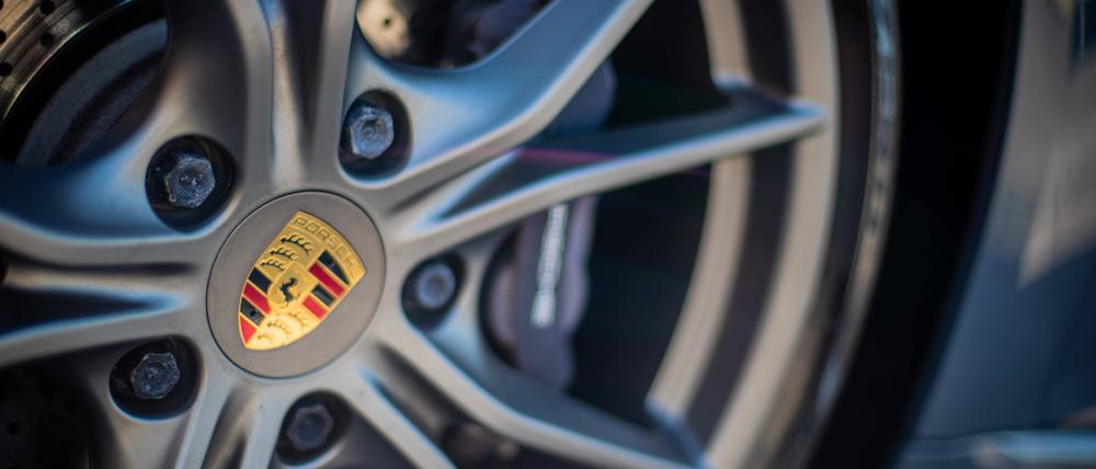 Das Porsche-Logo ist auf der Felge eines Autos.