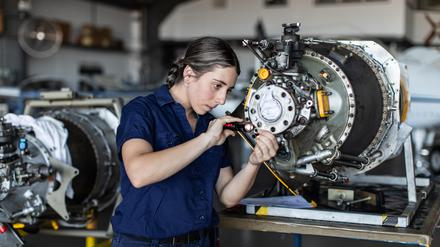 Eine Ingenieurin bei ihrer Arbeit mit Flugzeugtechnik (Symbolbild)