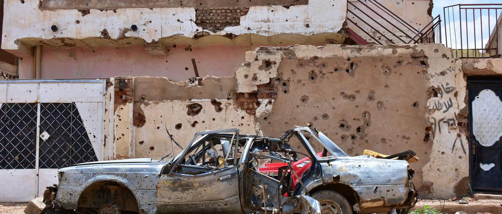Ein zerstörtes Auto steht im sudanesischen Omdurman vor einem Haus voller Einschüsse. (Archivbild)
