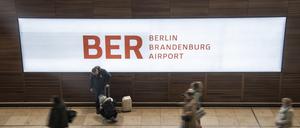 Reisende gehen durch das Terminal im Flughafen BER. 