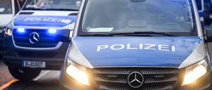 Polizeiautos mit eingeschalteten Scheinwerfern und Blaulicht