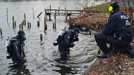 Polizeitaucher suchen nach einer Bombe im Wasser.