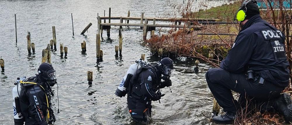 Polizeitaucher suchen nach einer Bombe im Wasser.