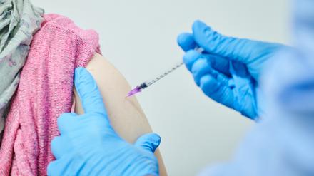 Medizinisches Fachpersonal setzt einer Patientin eine Spritze.