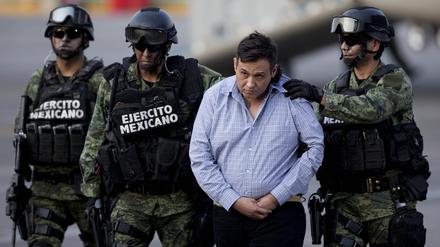 Soldaten eskortieren einen Mann, der von den Behörden als Omar Trevino Morales, alias „Z-42“, Anführer des Zetas-Drogenkartells, identifiziert wurde, während er von einem Militärflugzeug in ein Militärfahrzeug im Hangar der Generalstaatsanwaltschaft gebracht wird. 