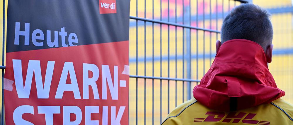 Ein warnstreikender DHL-Mitarbeiter an einem Standort der Post, die zu DHL gehört.