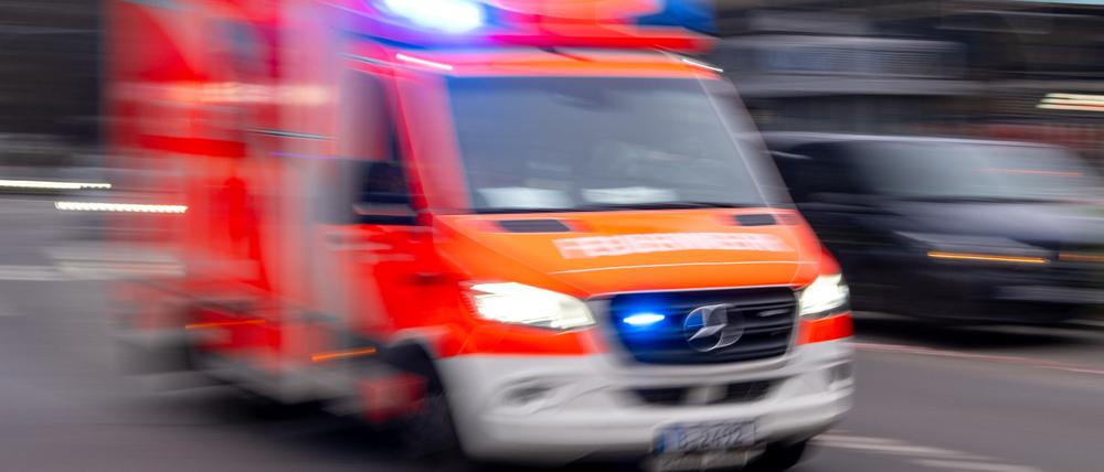 Ein Rettungswagen der Feuerwehr fährt mit Blaulicht zum Einsatz (Aufnahme mit Langzeitbelichtung).