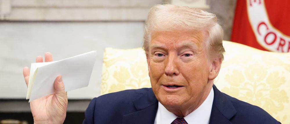 US-Präsident Donald Trump hält einen Brief des britischen Königs Charles, während er sich mit dem britischen Premierminister Keir Starmer (nicht im Bild) im Oval Office trifft (Archivbild).