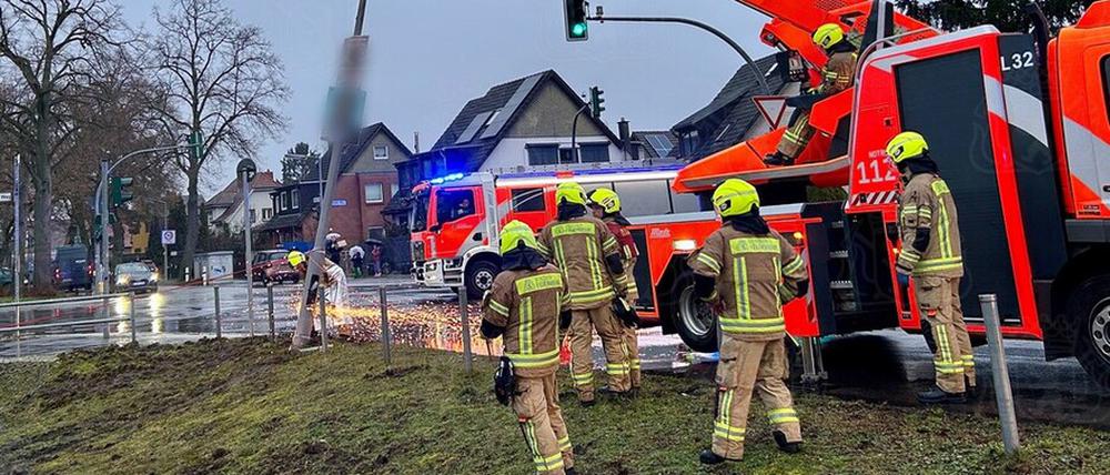 Die Feuerwehr entfernt eine Straßenlaterne mit einem Trennschleifer.
