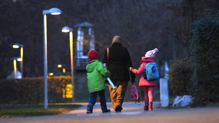 Eine Muslima mit Kopftuch holt ihre Kinder von der Schule ab.