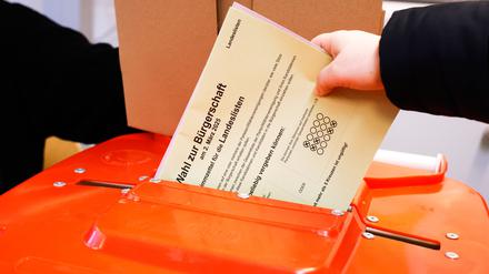 Eine Wählerin steckt ihren Stimmzettel in eine Wahlurne im Wahllokal in der Julius-Leber-Schule in Hamburg-Schnelsen. 