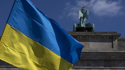 Die Fahne der Ukraine weht bei einer Protestaktion gegen den russischen Krieg in der Ukraine am Brandenburger Tor. +++ dpa-Bildfunk +++