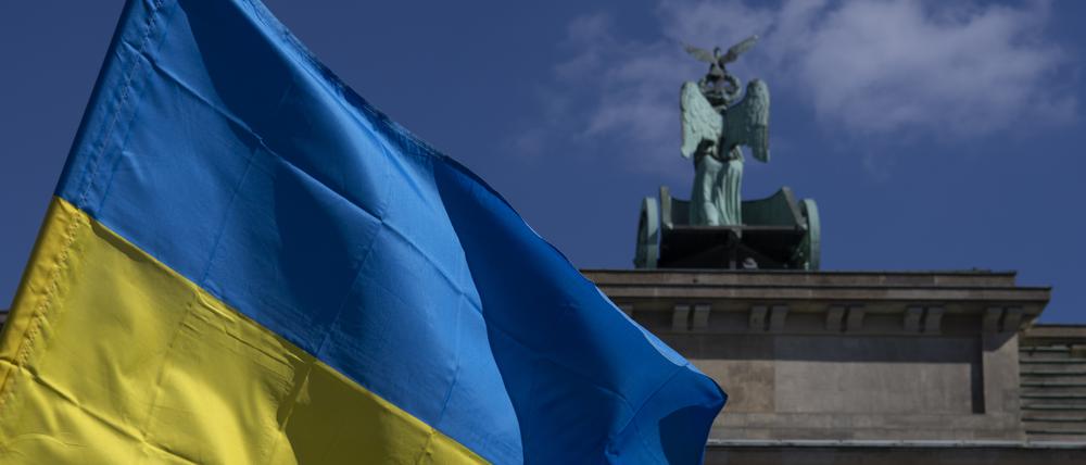 Die Fahne der Ukraine weht bei einer Protestaktion gegen den russischen Krieg in der Ukraine am Brandenburger Tor.