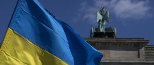 Die Fahne der Ukraine weht bei einer Protestaktion gegen den russischen Krieg in der Ukraine am Brandenburger Tor.
