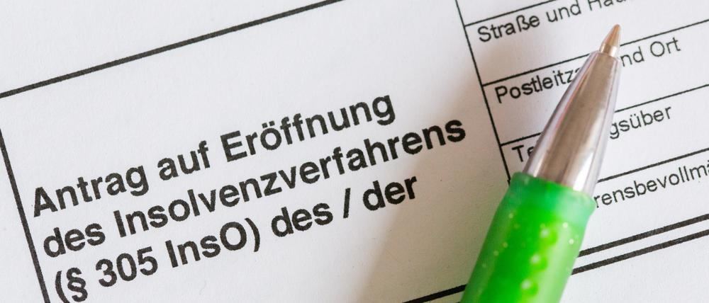 In Potsdam zuletzt häufiger benötigt: Ein Kugelschreiber liegt auf einem Antrag zur Eröffnung eines Insolvenzverfahrens.