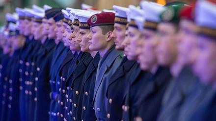 Bundeswehr-Rekruten in unterschiedlichen Uniformen stehen während eines feierlichen Gelöbnisses in einer Reihe. (Symbolbild)