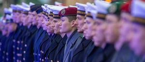 Bundeswehr-Rekruten in unterschiedlichen Uniformen stehen während eines feierlichen Gelöbnisses in einer Reihe. (Symbolbild)