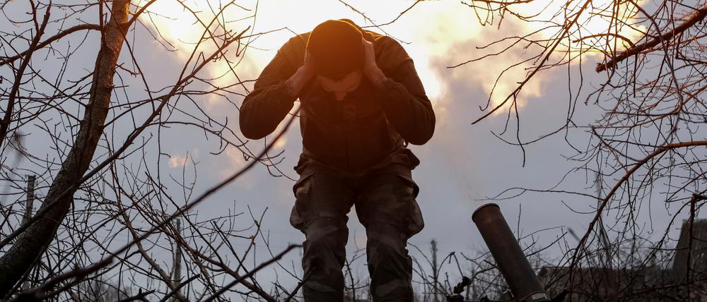 Ein Soldat der 57. motorisierten Infanteriebrigade hält sich nach dem Abschuss einer 120-mm-Mörsergranate an einer Frontlinie nahe Wowtschansk die Ohren zu.