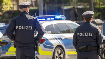 ARCHIV - 18.09.2024, Bayern, München: Polizisten stehen mit einem Streifenwagen am Haupteingang zum Oktoberfestgelände. (zu dpa: «Deutlich mehr Bewerbungen als Stellen bei Bayerns Polizei») Foto: Peter Kneffel/dpa +++ dpa-Bildfunk +++