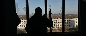 Ein Soldat schaut auf zerstörte Gebäude in Saporischja.