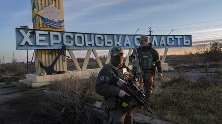 Zwei ukrainische Soldaten stehen neben einem Schild mit der Aufschrift „Gebiet Cherson“.