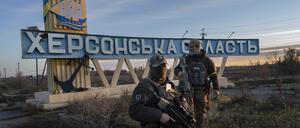 Zwei ukrainische Soldaten stehen neben einem Schild mit der Aufschrift „Gebiet Cherson“.