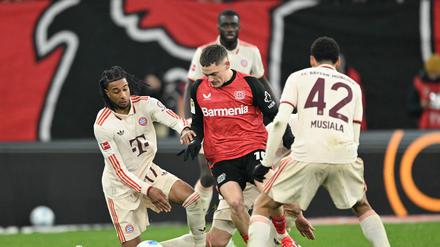 Wenn es sein muss, setzt sich Leverkusens Florian Wirtz (in rot) auch mal allein gegen drei Gegner durch.