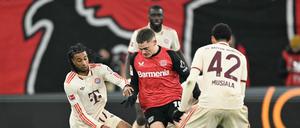 Wenn es sein muss, setzt sich Leverkusens Florian Wirtz (in rot) auch mal allein gegen drei Gegner durch.