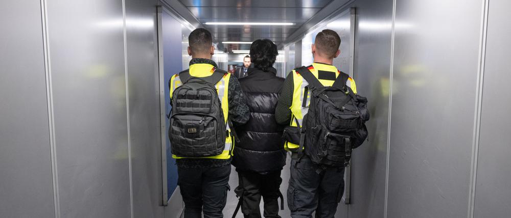 Beamte der Bundespolizei bringen einen Mann auf einen Abschiebeflug nach Pakistan.