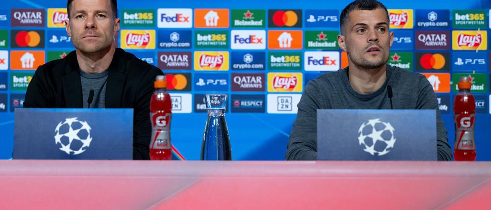 Trainer Xabi Alonso (l) und Granit Xhaka äußern sich bei der Pressekonferenz in der Allianz Arena zur Problematik möglicher Gelb-Sperren.