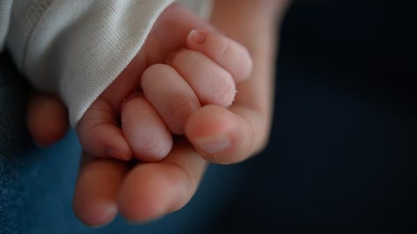 ARCHIV - 02.02.2020, Baden-Württemberg, Stuttgart: Die Hand eines zwei Wochen alten Neugeborenen liegt in der Hand seiner Mutter. (zu dpa: «Mutter bietet Baby im Internet an») Foto: Sebastian Gollnow/dpa +++ dpa-Bildfunk +++