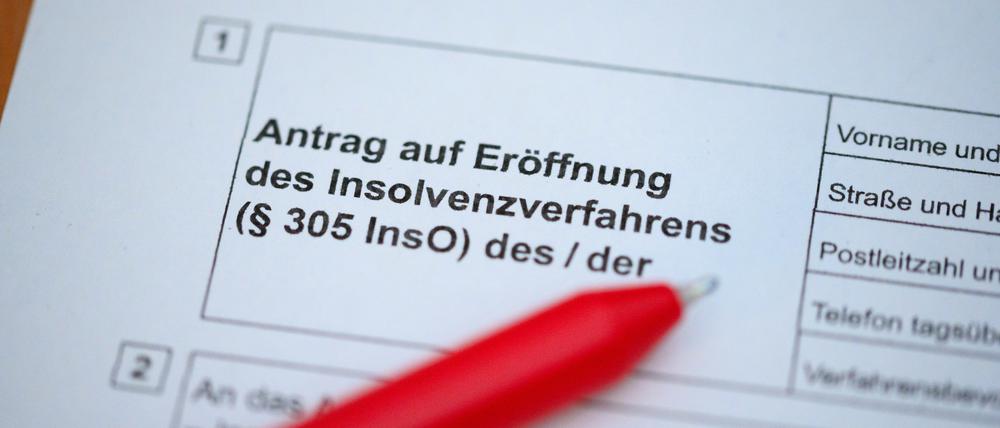 Ein Kugelschreiber liegt auf einem Antrag zur Eröffnung eines Insolvenzverfahrens.