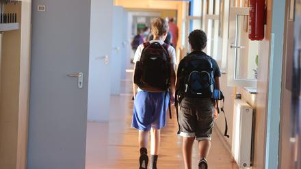 Schüler gehen zum Unterricht einen Gang entlang.