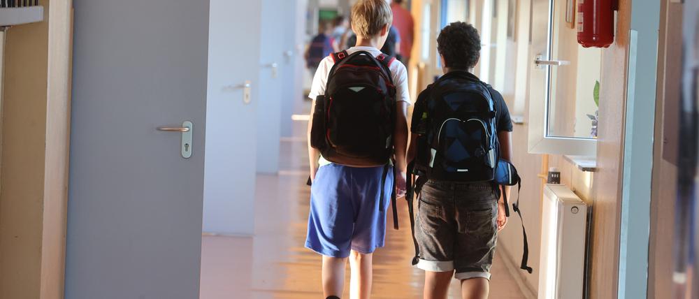 Schüler gehen zum Unterricht einen Gang entlang.