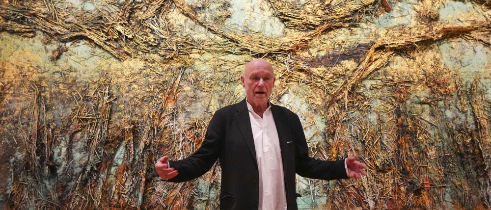 Unscheinbarer Mann mit großer malerischer Geste. Anselm Kiefer vor seinem Kunstwerk „Die Sternennacht“ in Amsterdam.