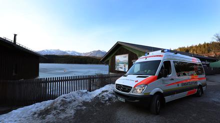 Ein Einsatzfahrzeug des Roten Kreuzes steht am Ufer des Eibsees, nahe der Stelle an der am Nachmittag mehrere Menschen im Eis eingebrochen waren.