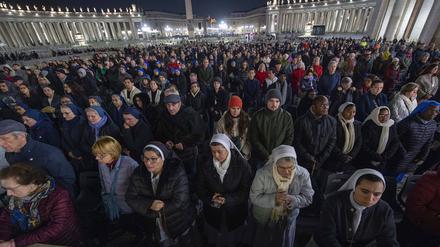 Gläubige beten während eines Rosenkranzgebets für die Gesundheit von Papst Franziskus auf dem Petersplatz.